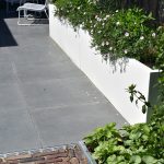 Landelijke tuin met witte bloembakken, GeoCeramica en oud gebakken waalformaat